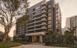 Prédio residencial moderno com arquitetura contemporânea, varandas e paisagismo, fotografado com luz natural suave.