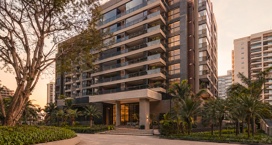 Prédio residencial moderno com arquitetura contemporânea, varandas e paisagismo, fotografado com luz natural suave.